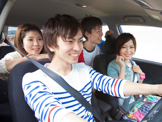笑顔で運転をする男女